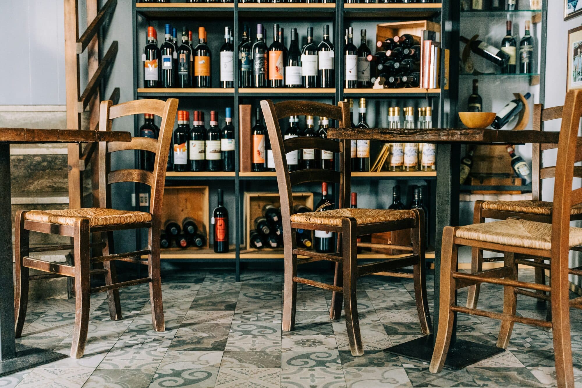 Dégustation de vins autour d'une table, verres à la main et chaises en bois et en paille